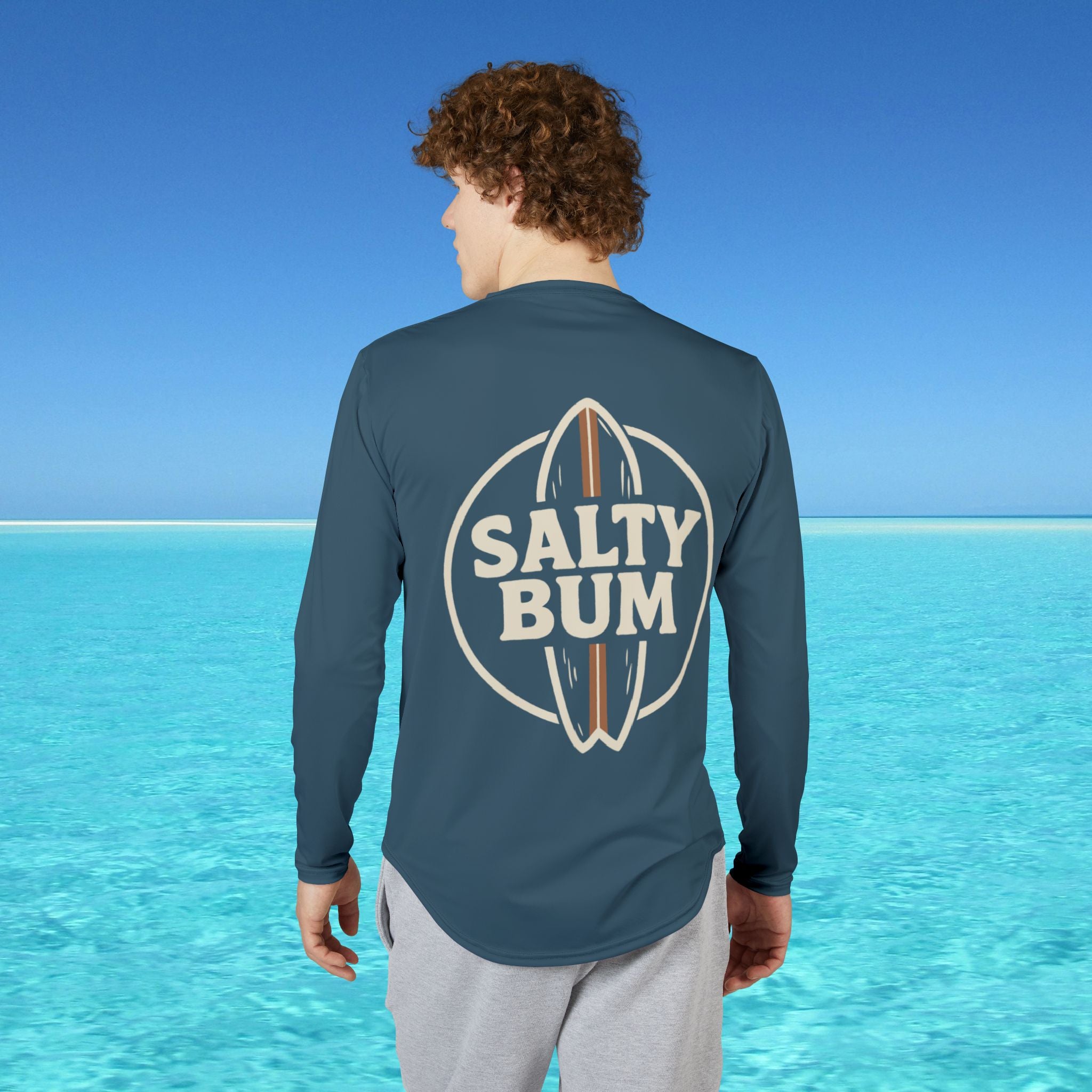 Person wearing a 'Salty Bum' shirt with a blue ocean and sky background