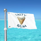 Flag with 'Salty Bum' text and a shark tooth graphic against a blue ocean and sky background.