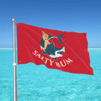 Red flag with 'Salty Bum' design against a clear blue sky and ocean.