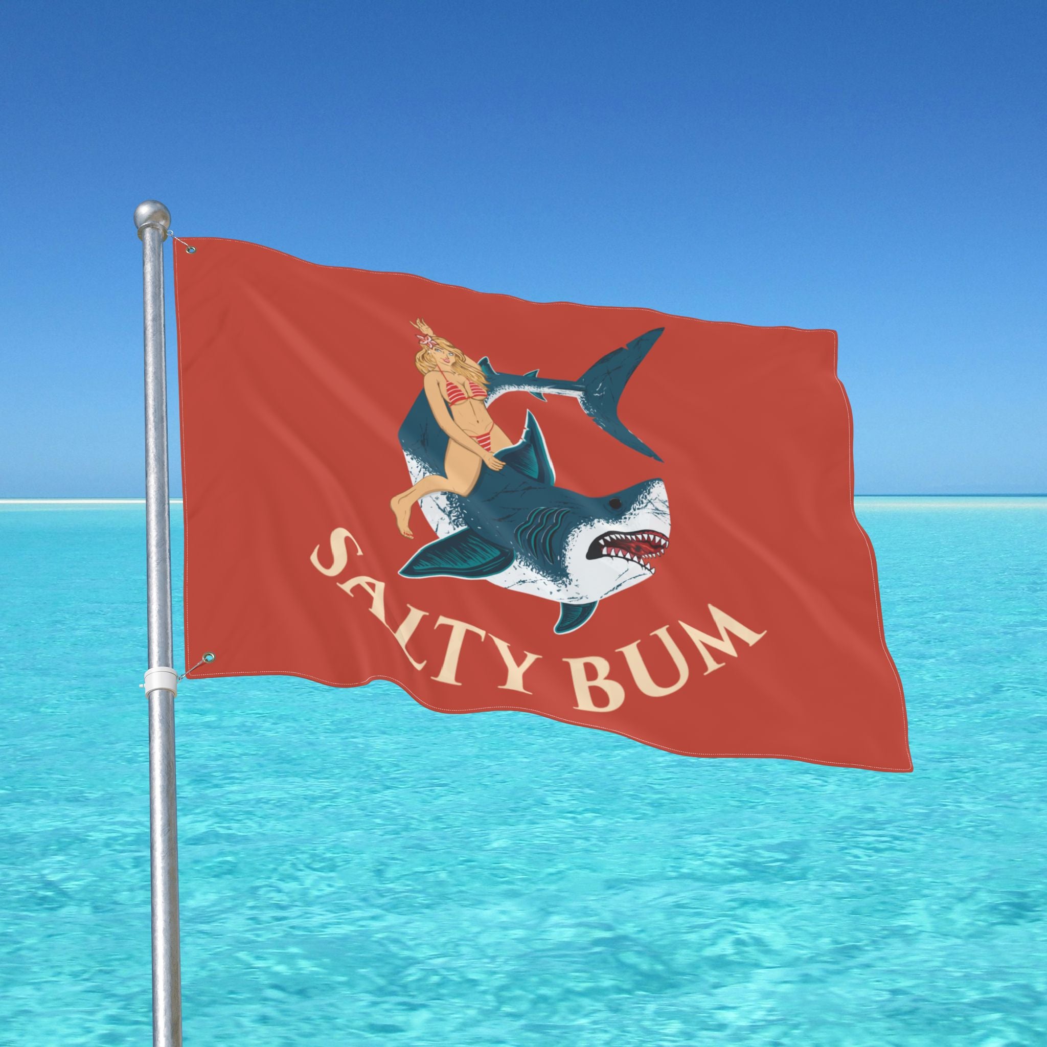 Flag with a shark and mermaid design against a blue ocean background