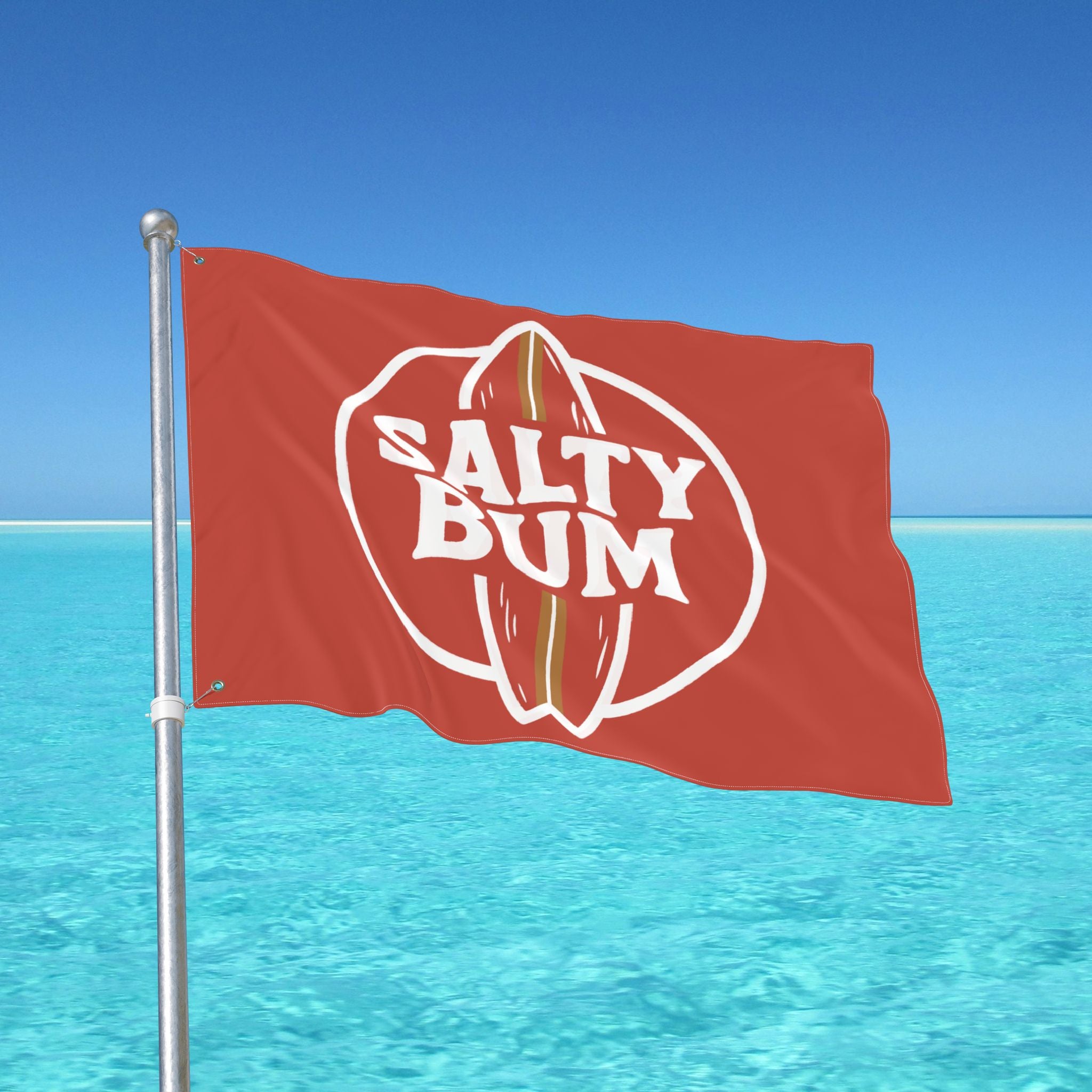 Flag with 'Salty Bum' logo against a clear blue sky and ocean.