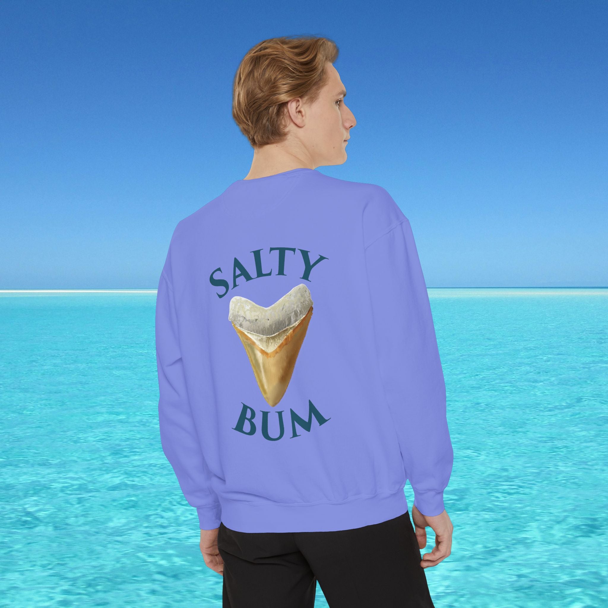 Person wearing a purple sweatshirt with 'Salty Bum' text and ice cream graphic, standing in front of a blue ocean.