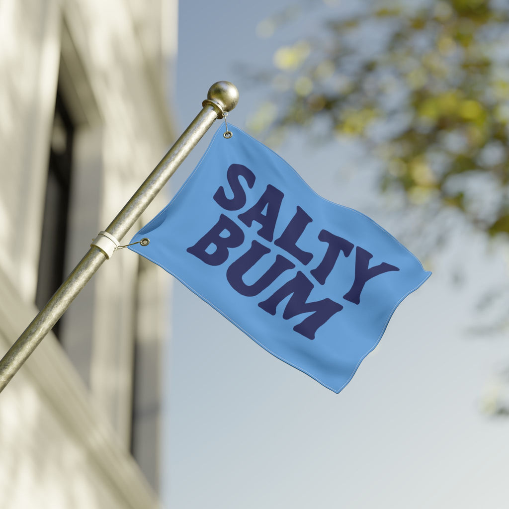 Blue flag with 'Salty Bum' text on a pole against a blurred background
