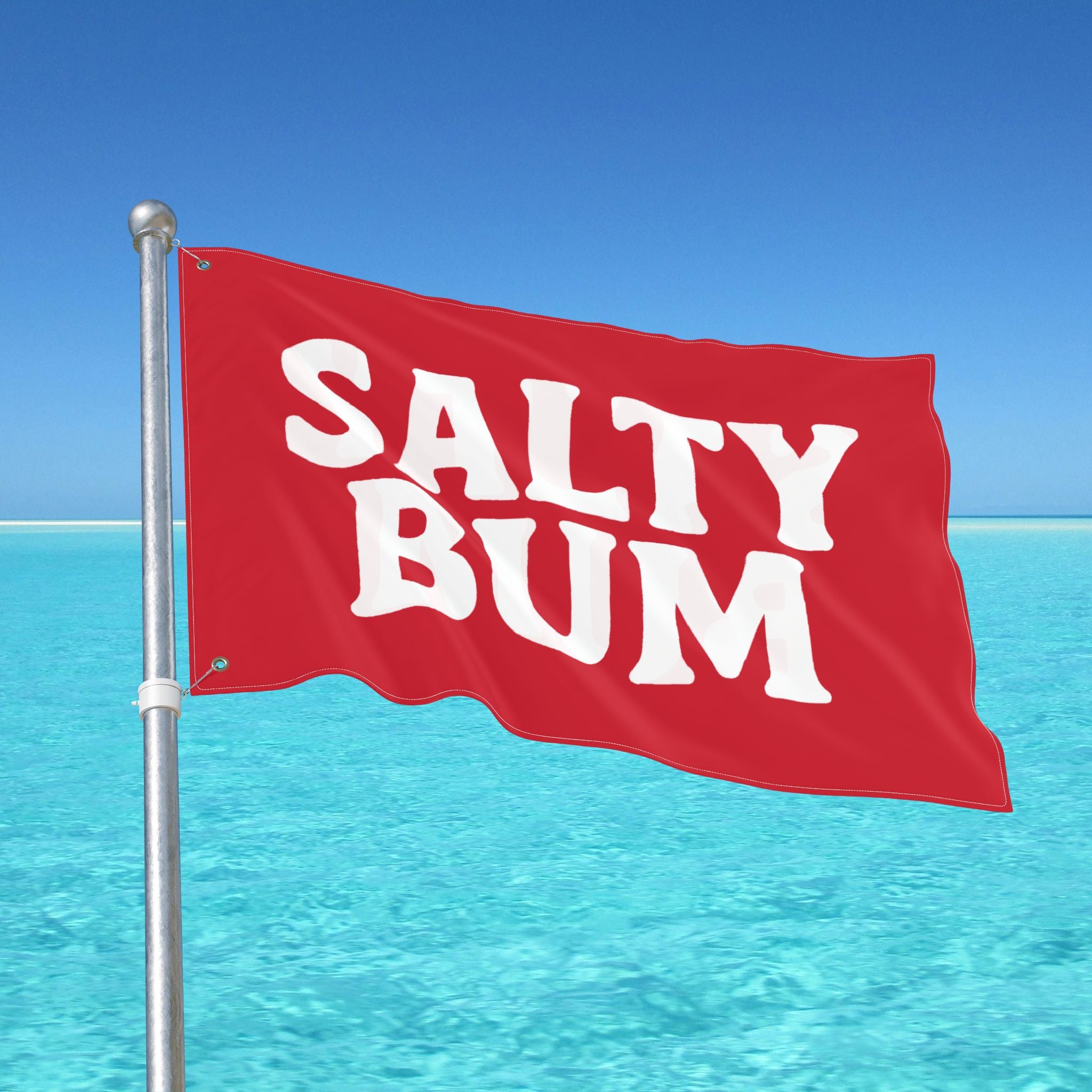Red flag with 'Salty Bum' text against a clear blue sky and ocean.