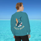 Person wearing a teal sweatshirt with a shark and bikini graphic and 'Salty Bum' text, standing in front of a blue ocean.