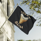 Flag with a shark tooth graphic and 'Salty Bum' text on a building exterior.