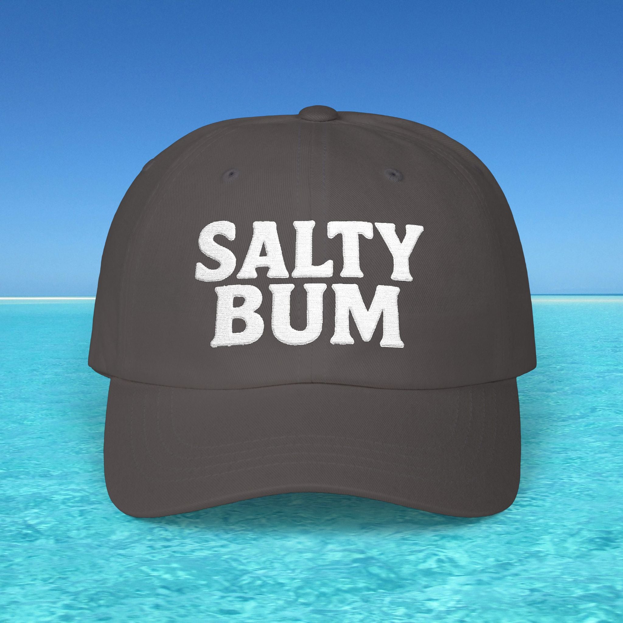 Dark gray cap with 'Salty Bum' text on a blue water and sky background