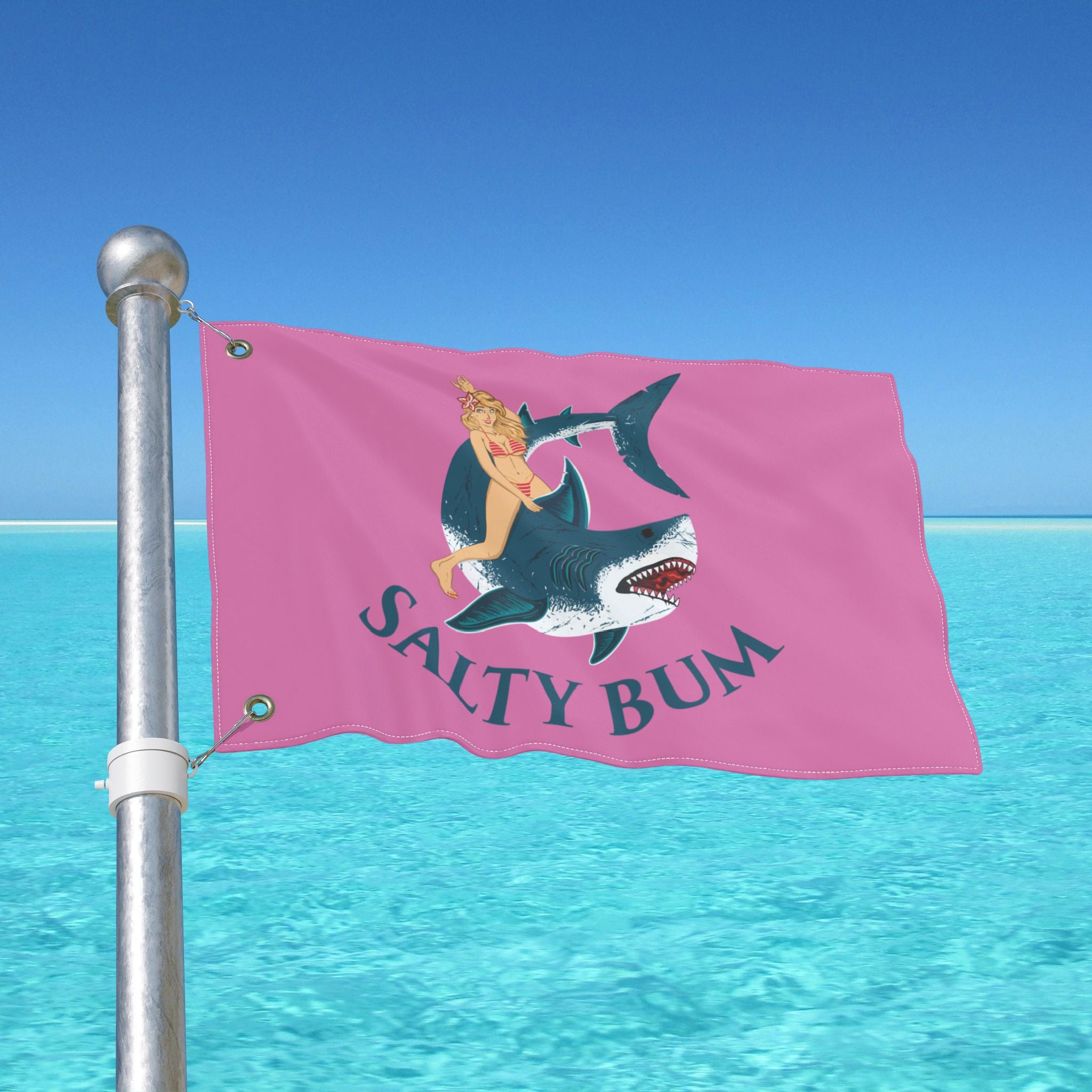 Pink flag with a graphic of a woman on a shark and 'Salty Bum' text, against a clear blue sky.
