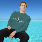 Person wearing a green sweatshirt with 'Salty Bum' graphic sitting on a chair with a blue water and sky background.