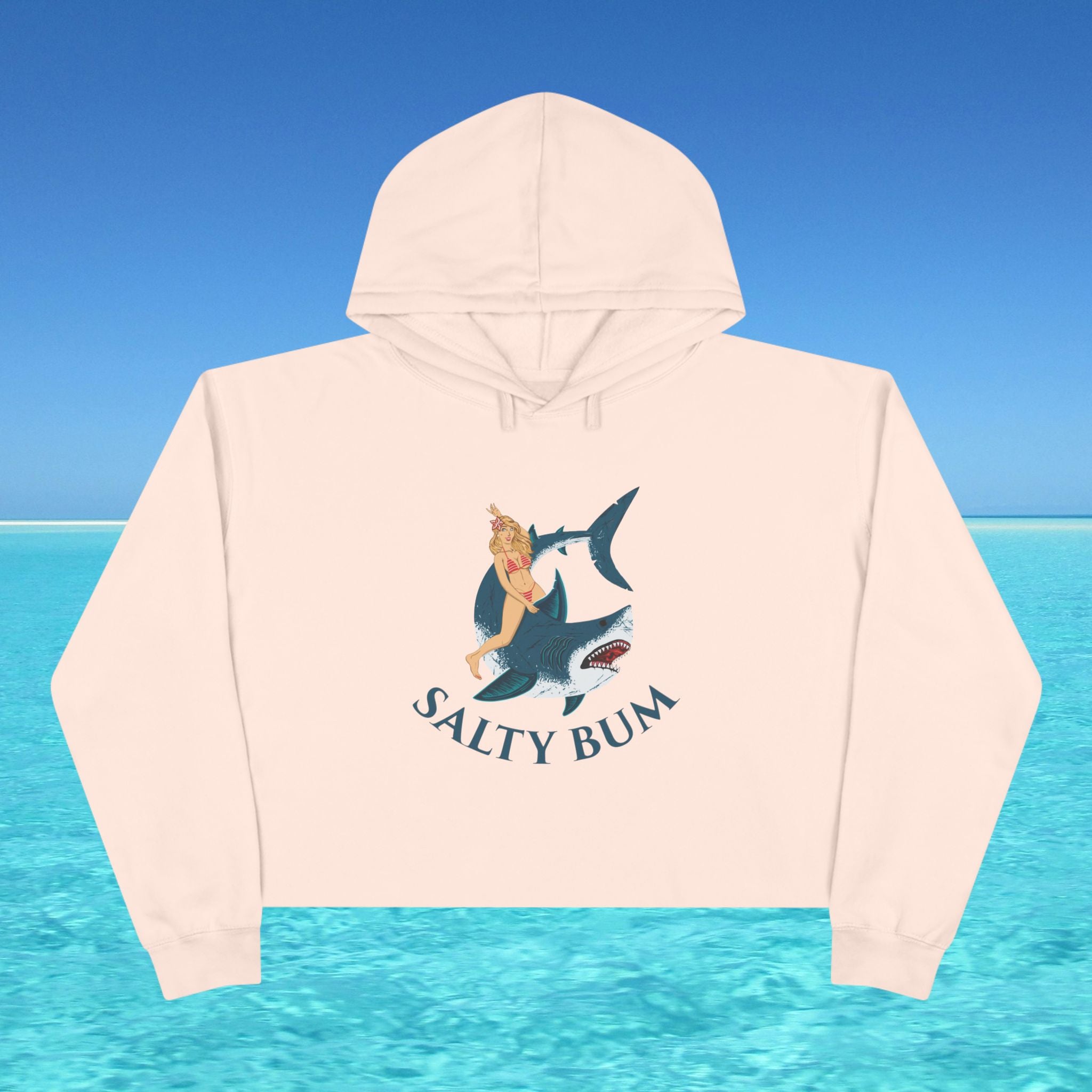 Beige hoodie with 'Salty Bum' graphic design on a blue water and sky background