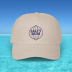 Beige cap with 'Salty Bum' logo on a blue water and sky background