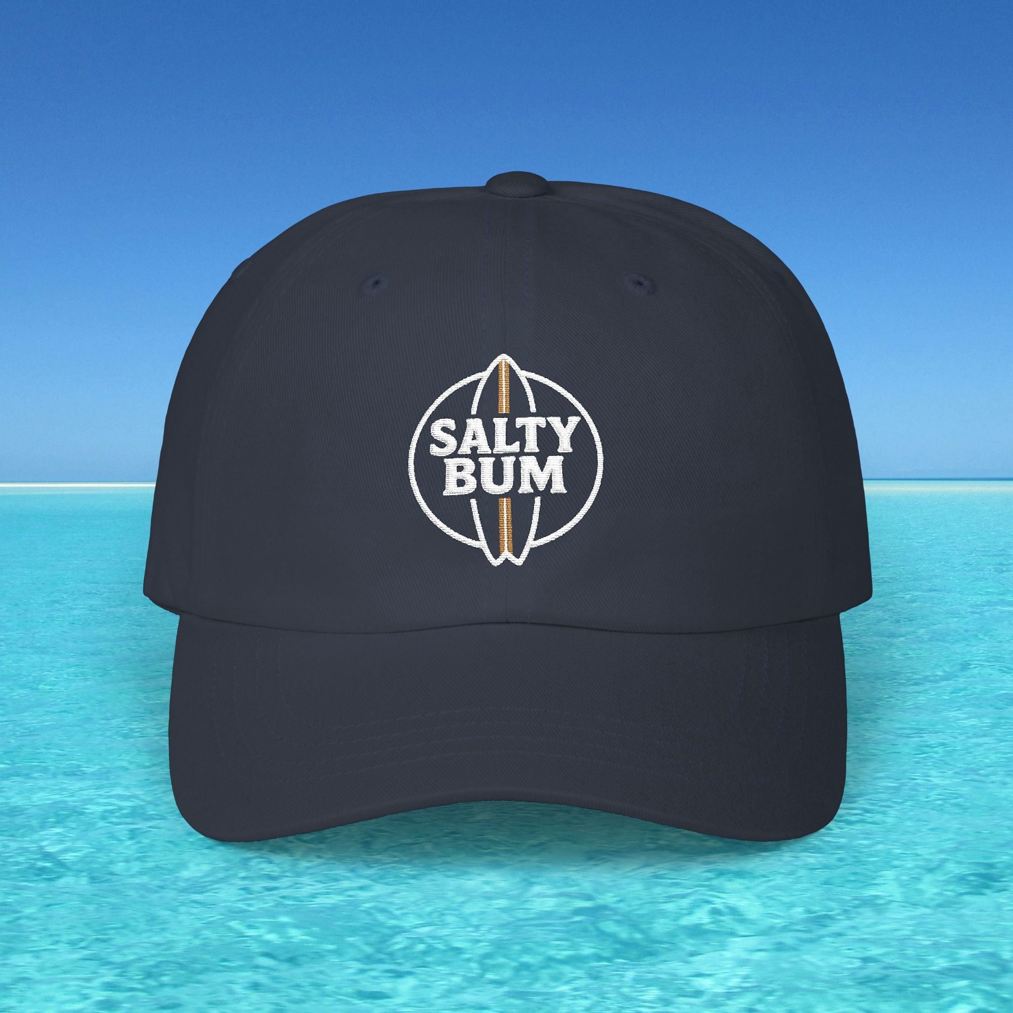 Black cap with 'Salty Bum' logo on a blue water and sky background