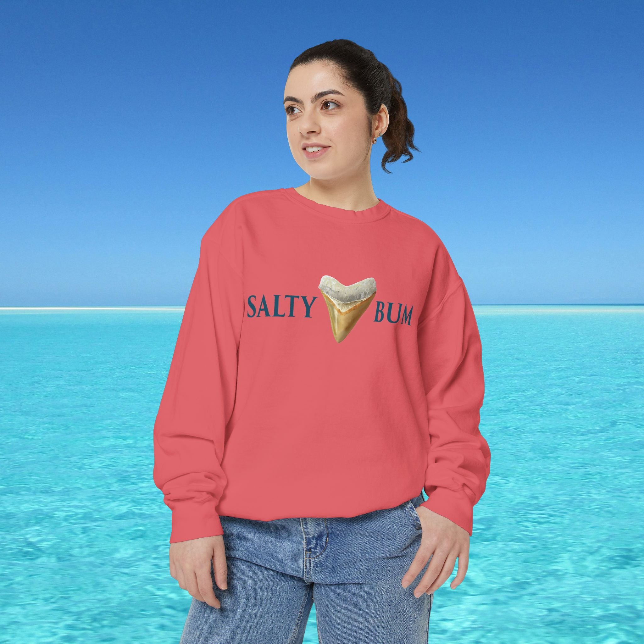 Person wearing a red sweatshirt with 'Salty Bum' text and ice cream graphic against a blue ocean background
