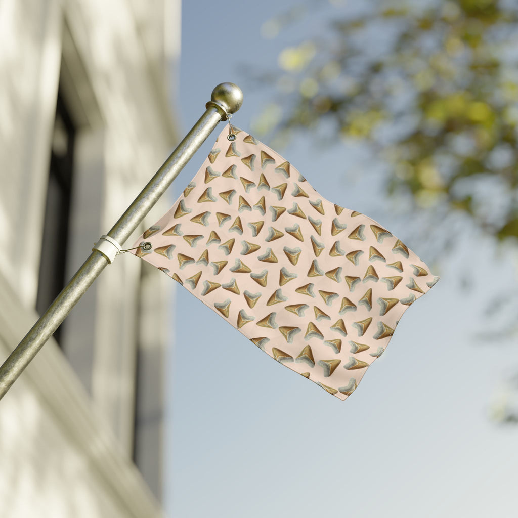 Decorative metal flag with geometric pattern on a flagpole against a blurred outdoor background