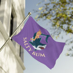 Purple flag with a mermaid and shark design, featuring the text 'Salty Bum', against a blurred outdoor background.