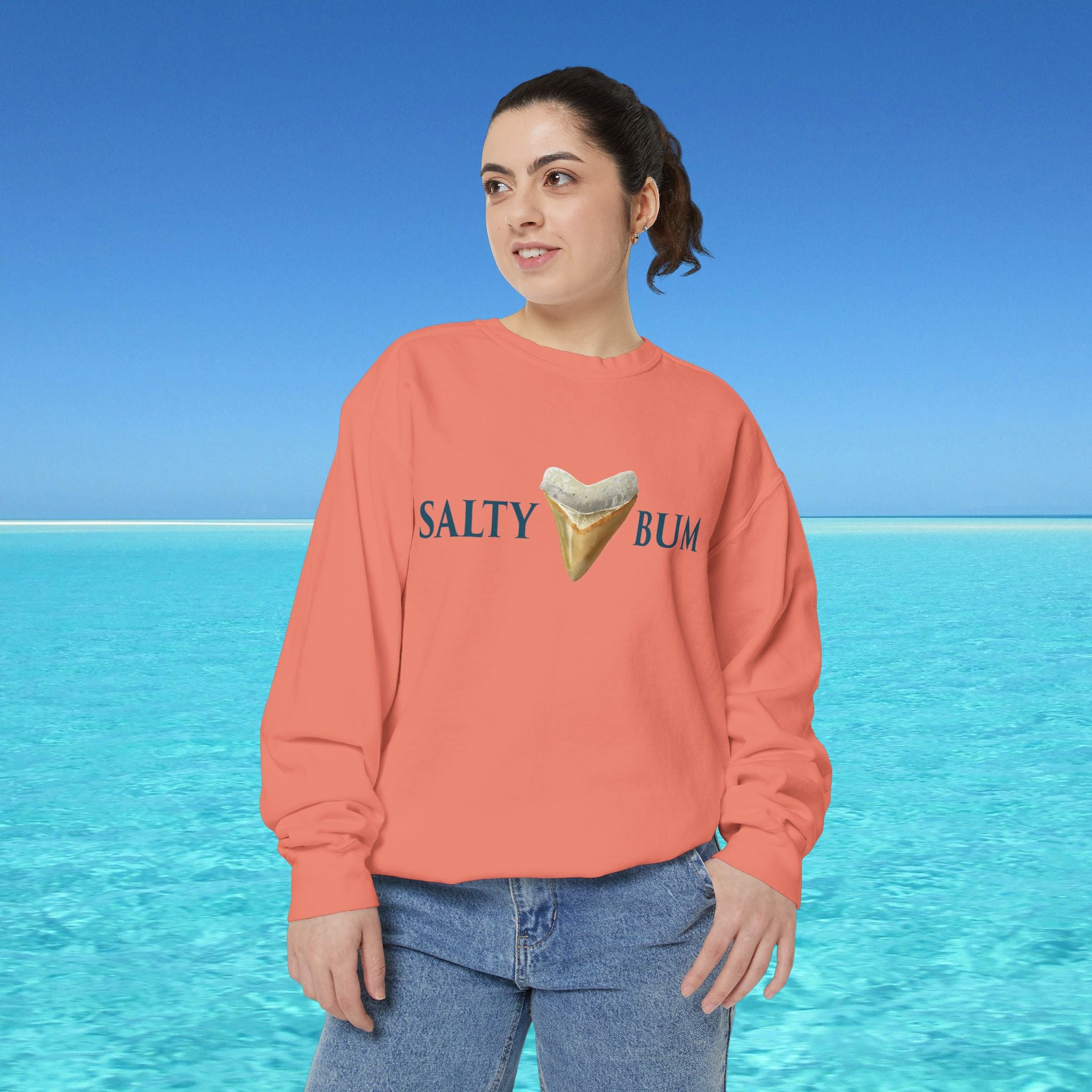 Person wearing a 'Salty Bum' sweatshirt with a beach background