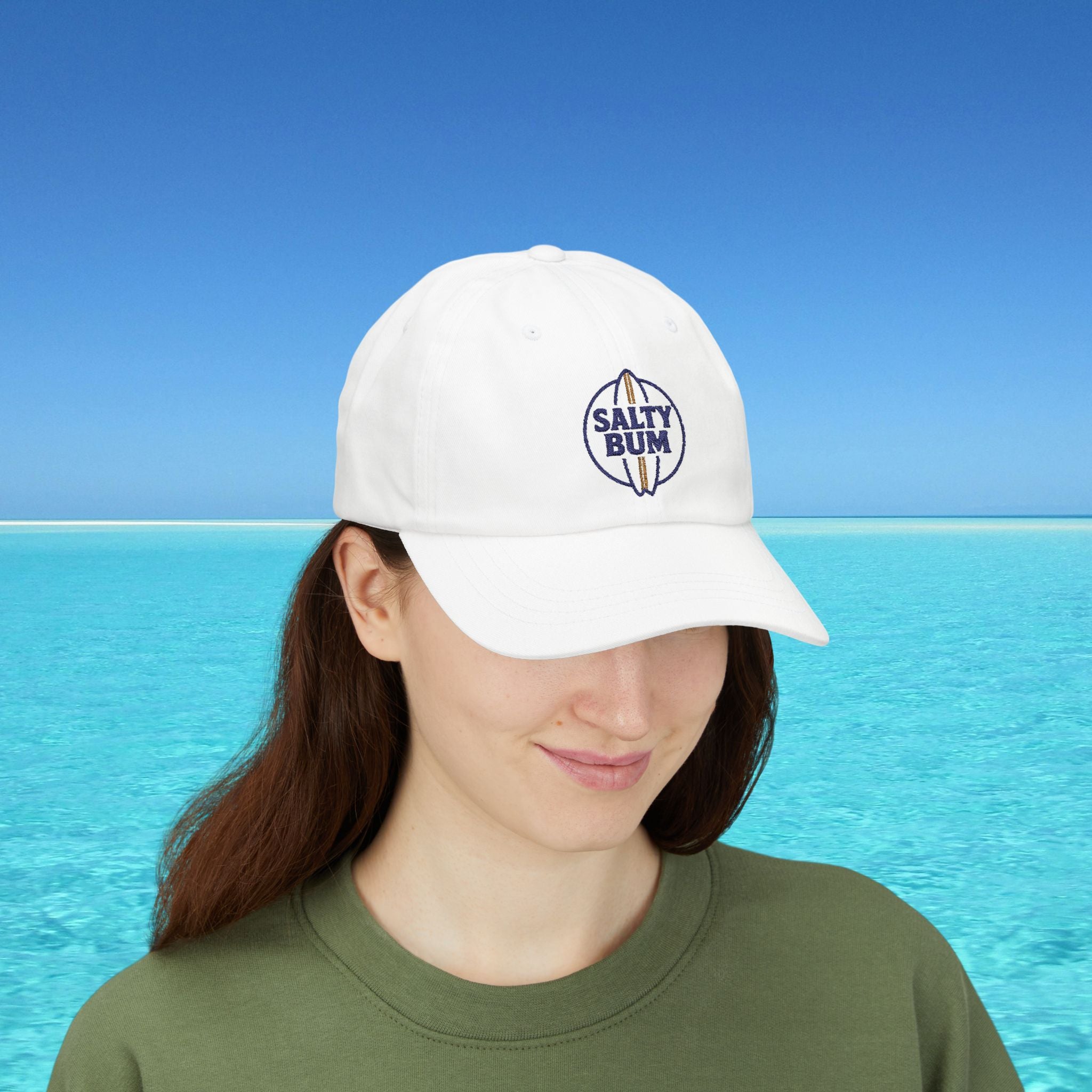 Person wearing a white cap with 'Salty Bum' logo against a blue ocean background