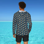 Person wearing a patterned jacket standing in front of a clear blue ocean.
