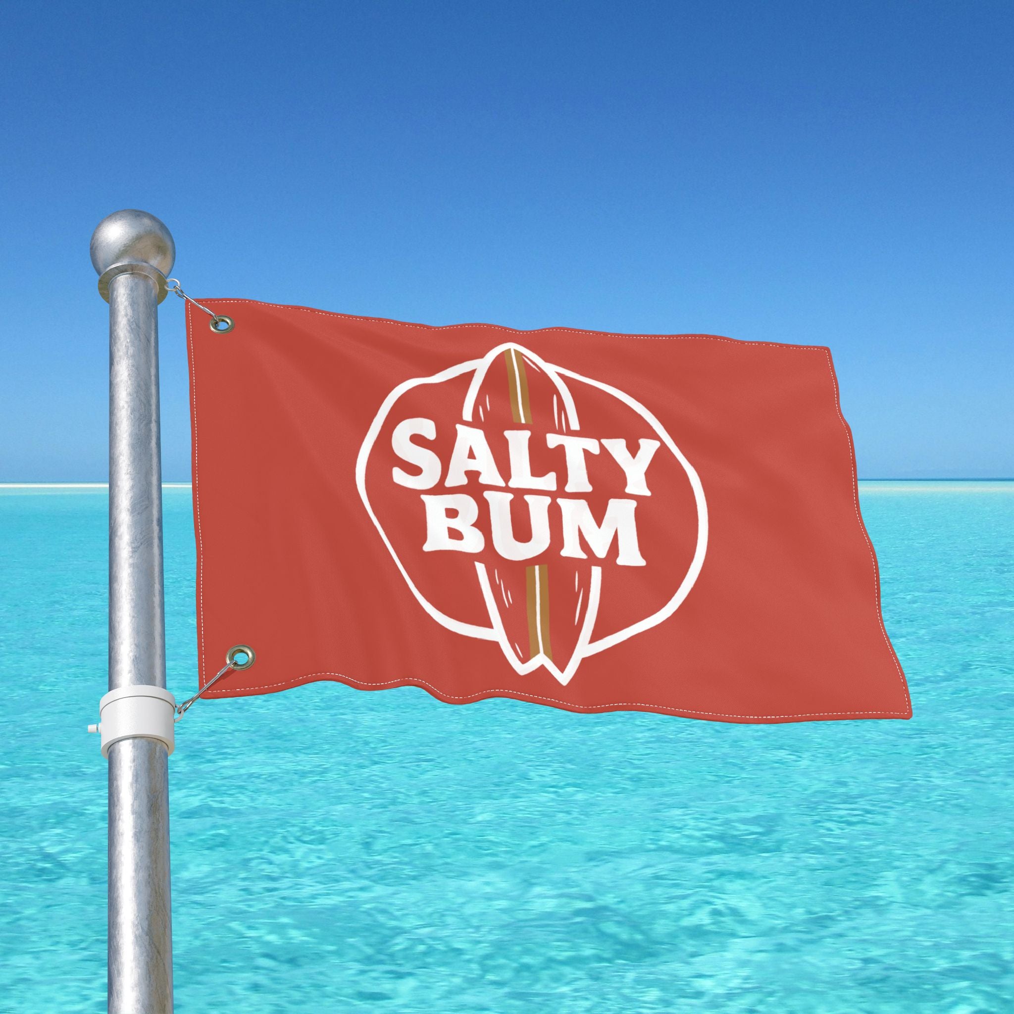 Red flag with 'Salty Bum' logo against a clear blue sky and ocean.