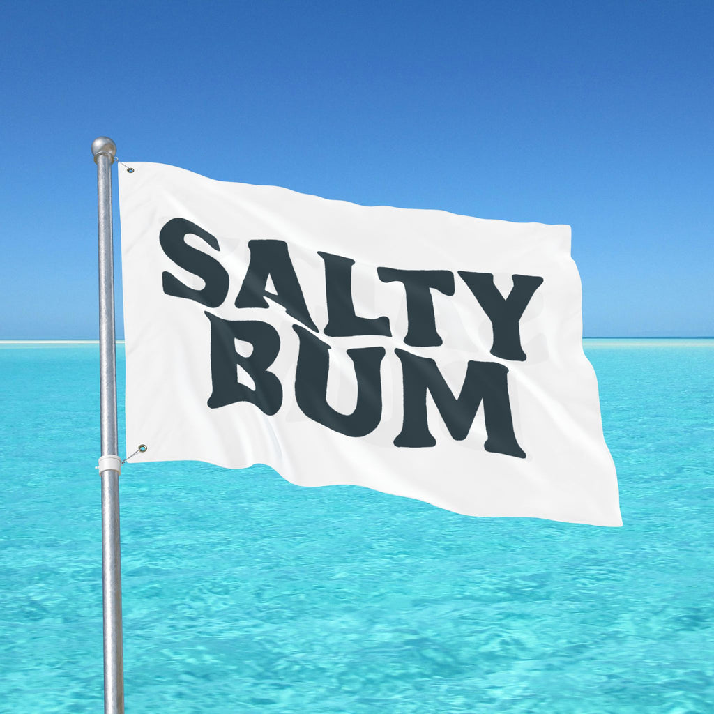 Flag with 'Salty Bum' text against a clear blue sky and ocean background
