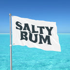 Flag with 'Salty Bum' text against a clear blue sky and ocean background