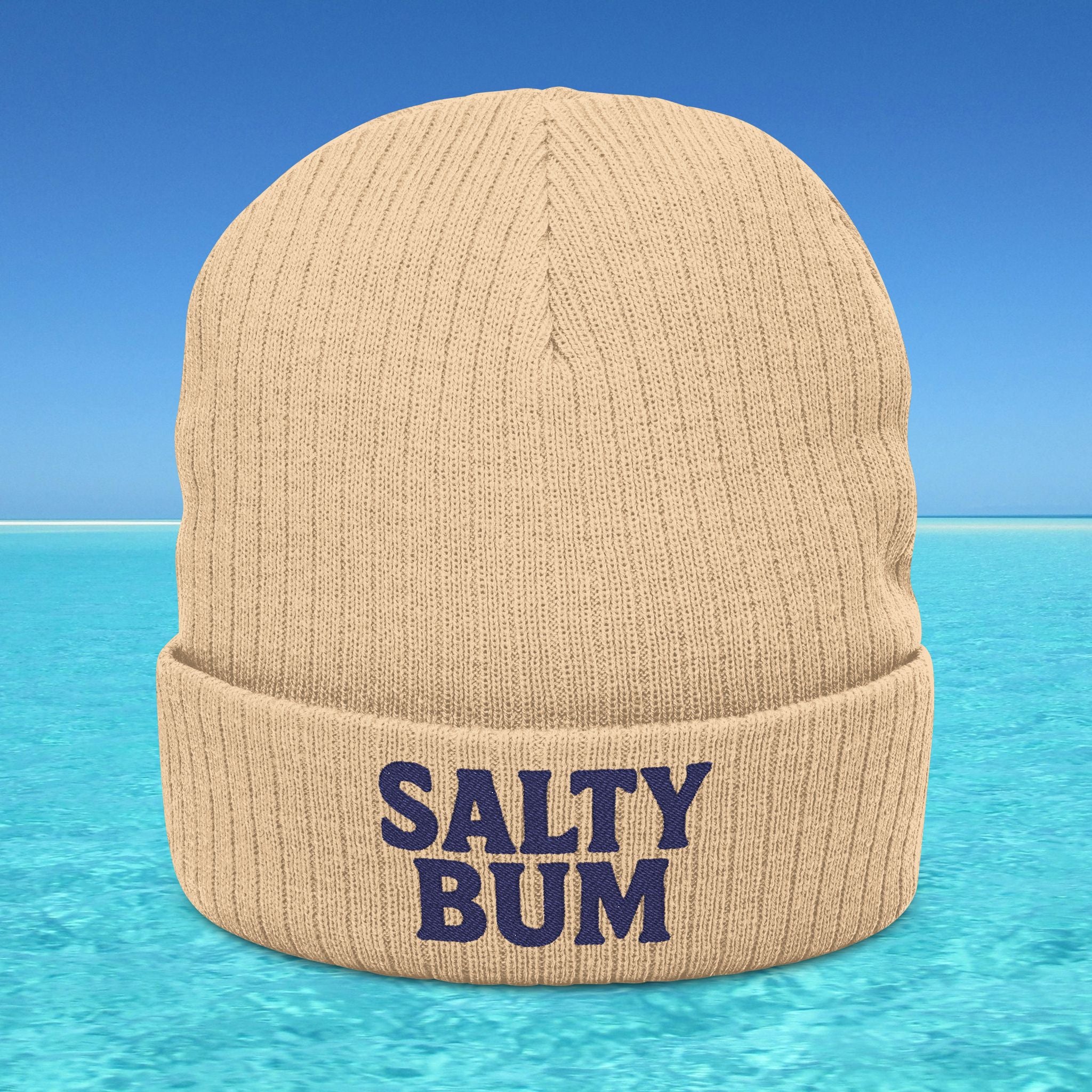 Beige beanie with 'Salty Bum' text on a beach background