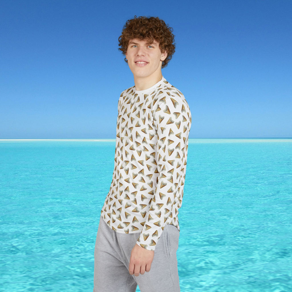 Person wearing a geometric patterned shirt standing in front of clear blue water and sky.