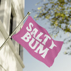 Pink flag with 'Salty Bum' text on a pole against a blurred background