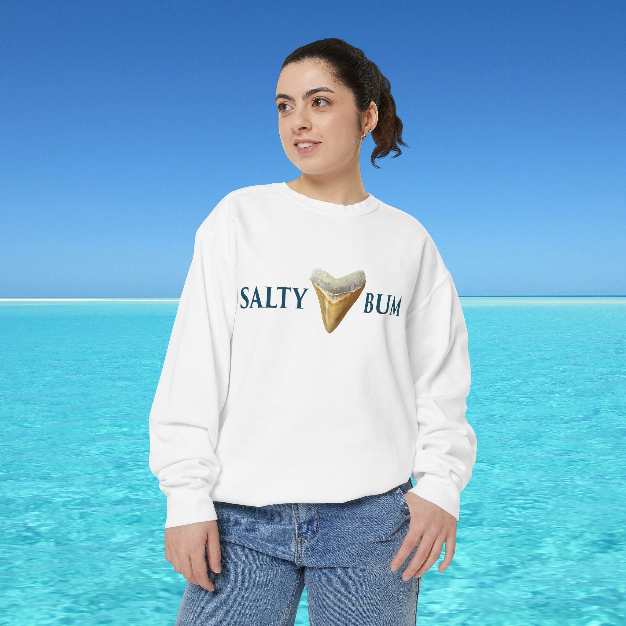 Person wearing a white sweatshirt with 'Salty Bum' text and ice cream graphic against a blue ocean background