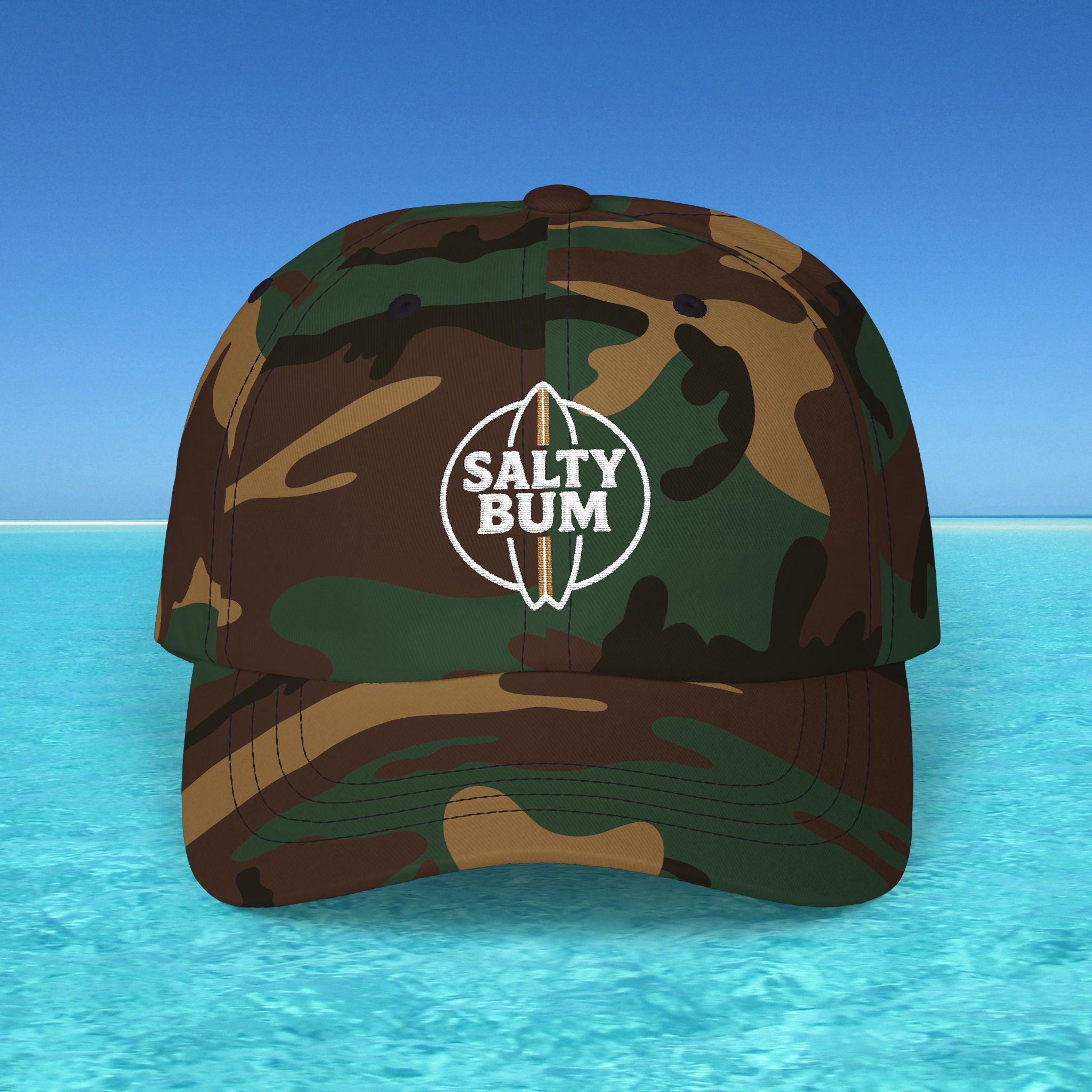 Camouflage cap with 'Salty Bum' logo on a beach background