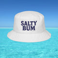 White bucket hat with 'Salty Bum' text floating on clear blue water with a blue sky background
