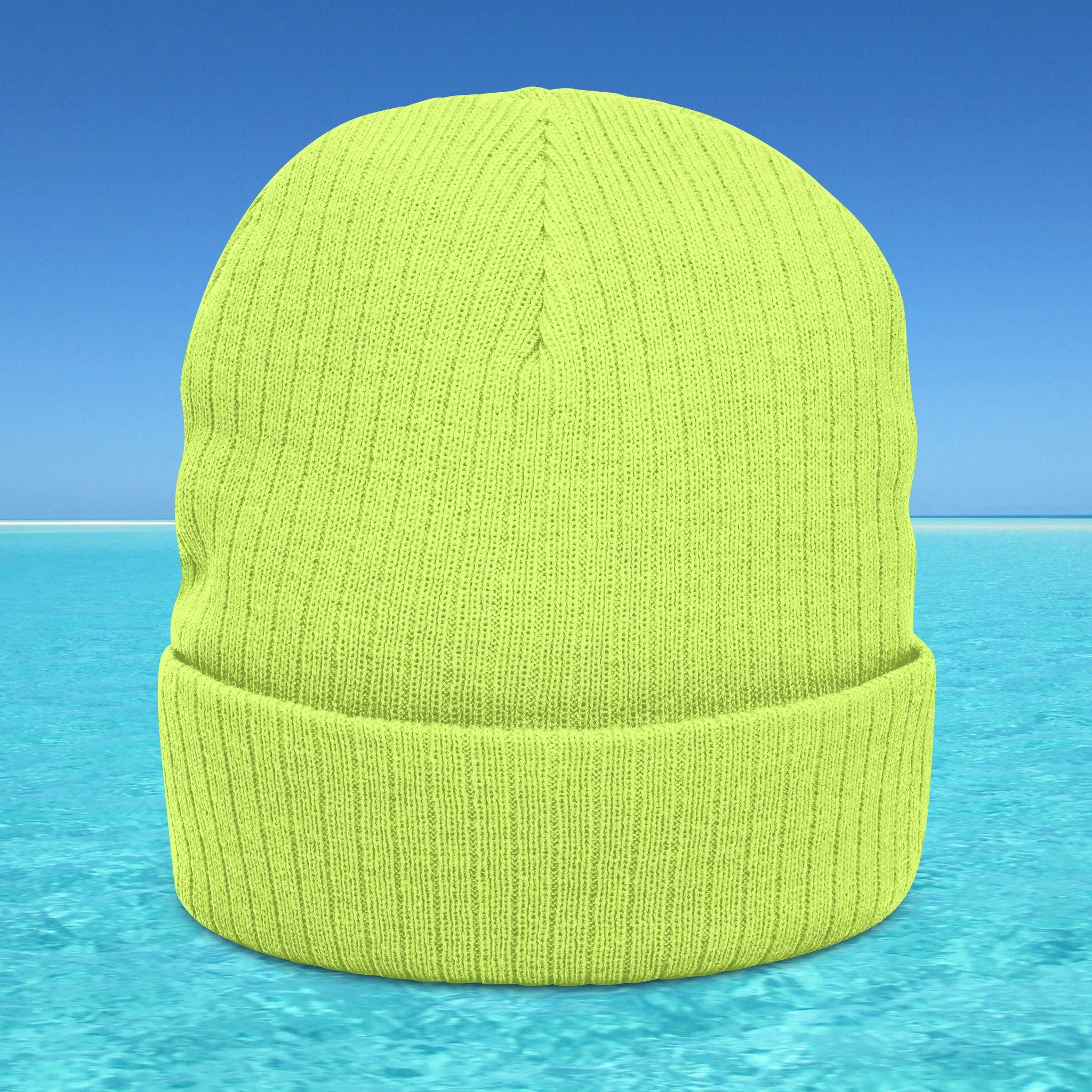 Green knit beanie on a blue water and sky background