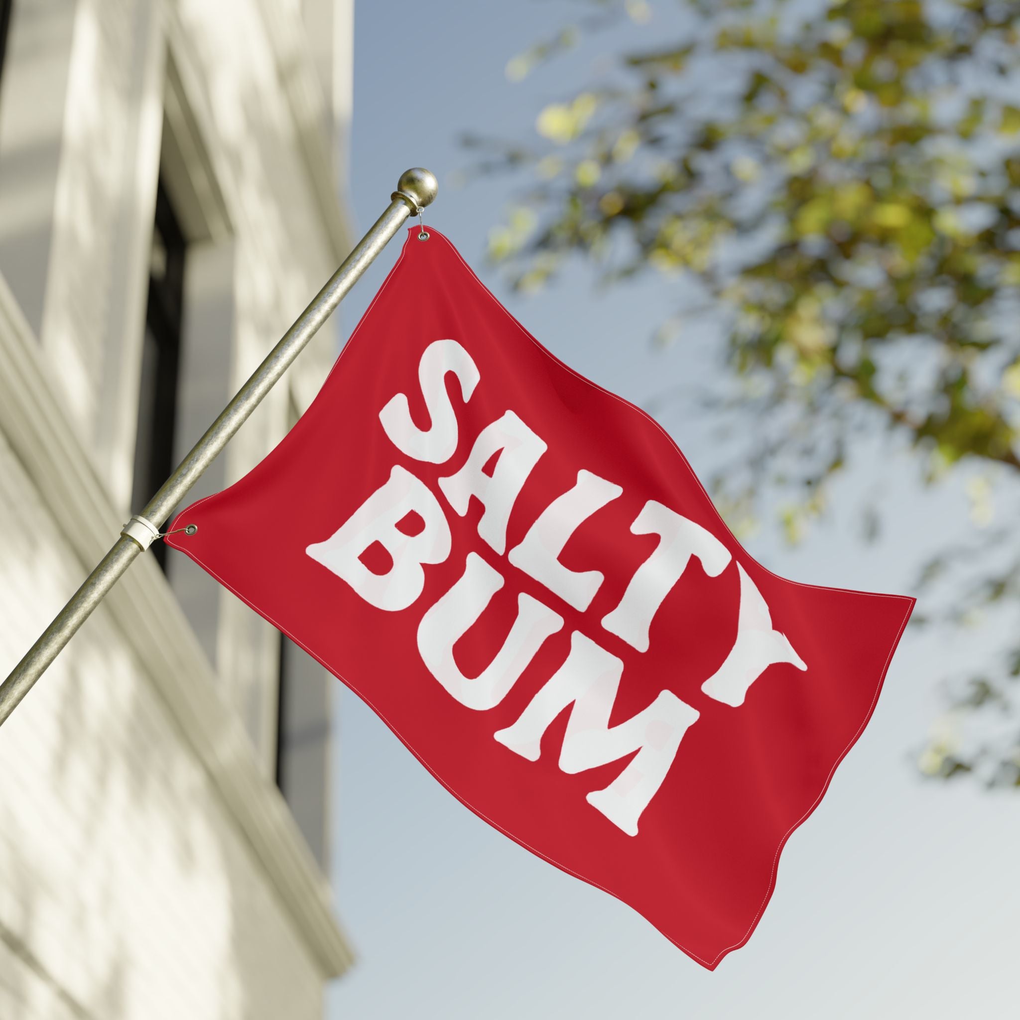 Red flag with 'Salty Bum' text on a pole against a blurred background