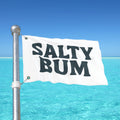 Flag with 'Salty Bum' text against a clear blue sky and ocean.