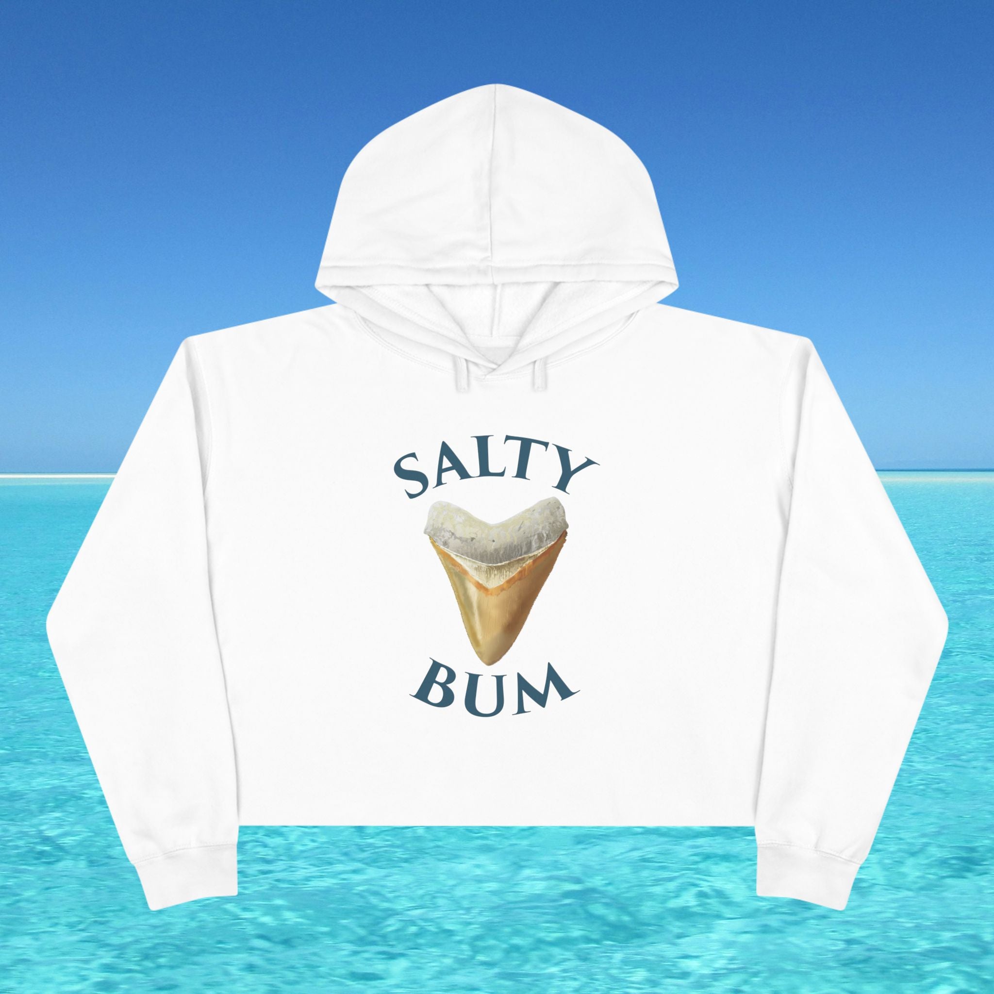 White hoodie with 'Salty Bum' text and shark tooth graphic against a blue ocean background