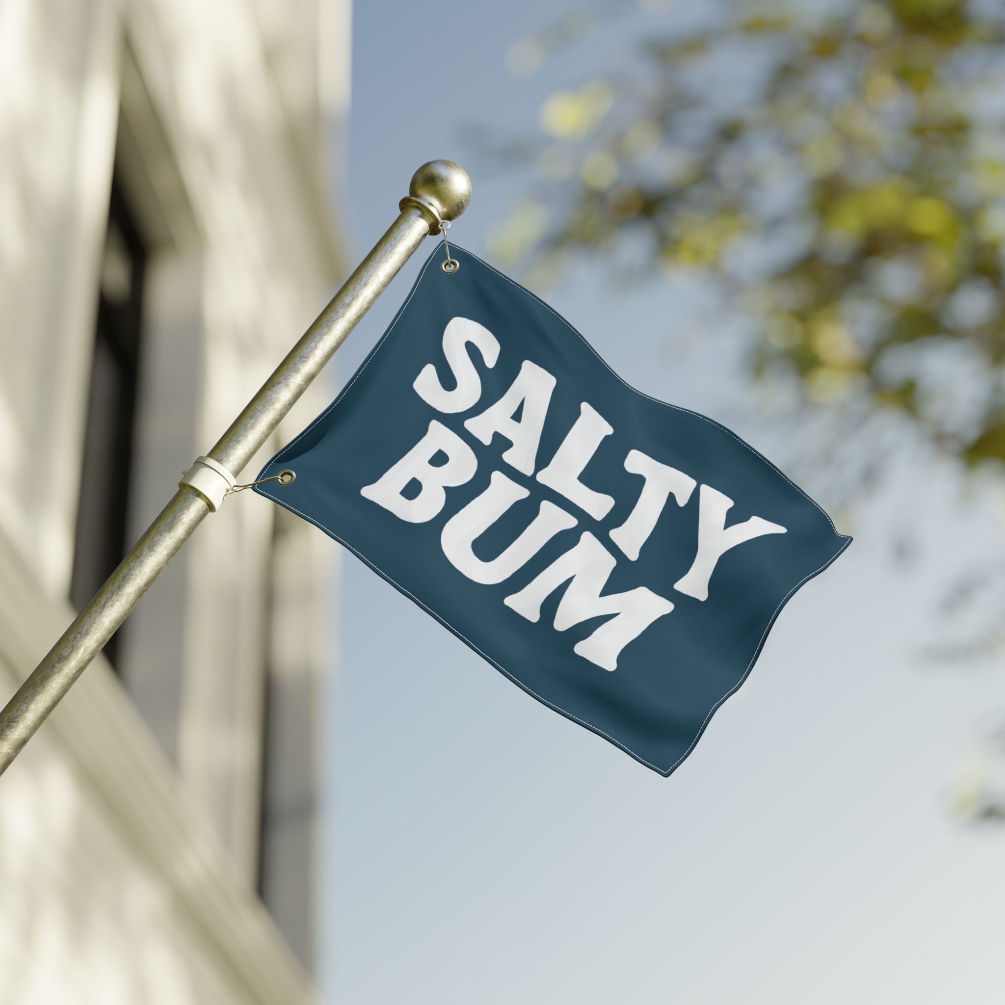 Navy blue flag with 'Salty Bum' text on a pole against a blurred background