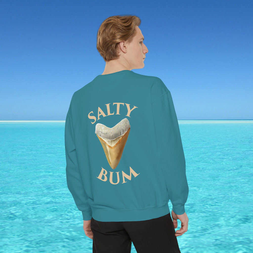 Person wearing a teal sweatshirt with 'Salty Bum' text and ice cream cone graphic, standing in front of a blue ocean.