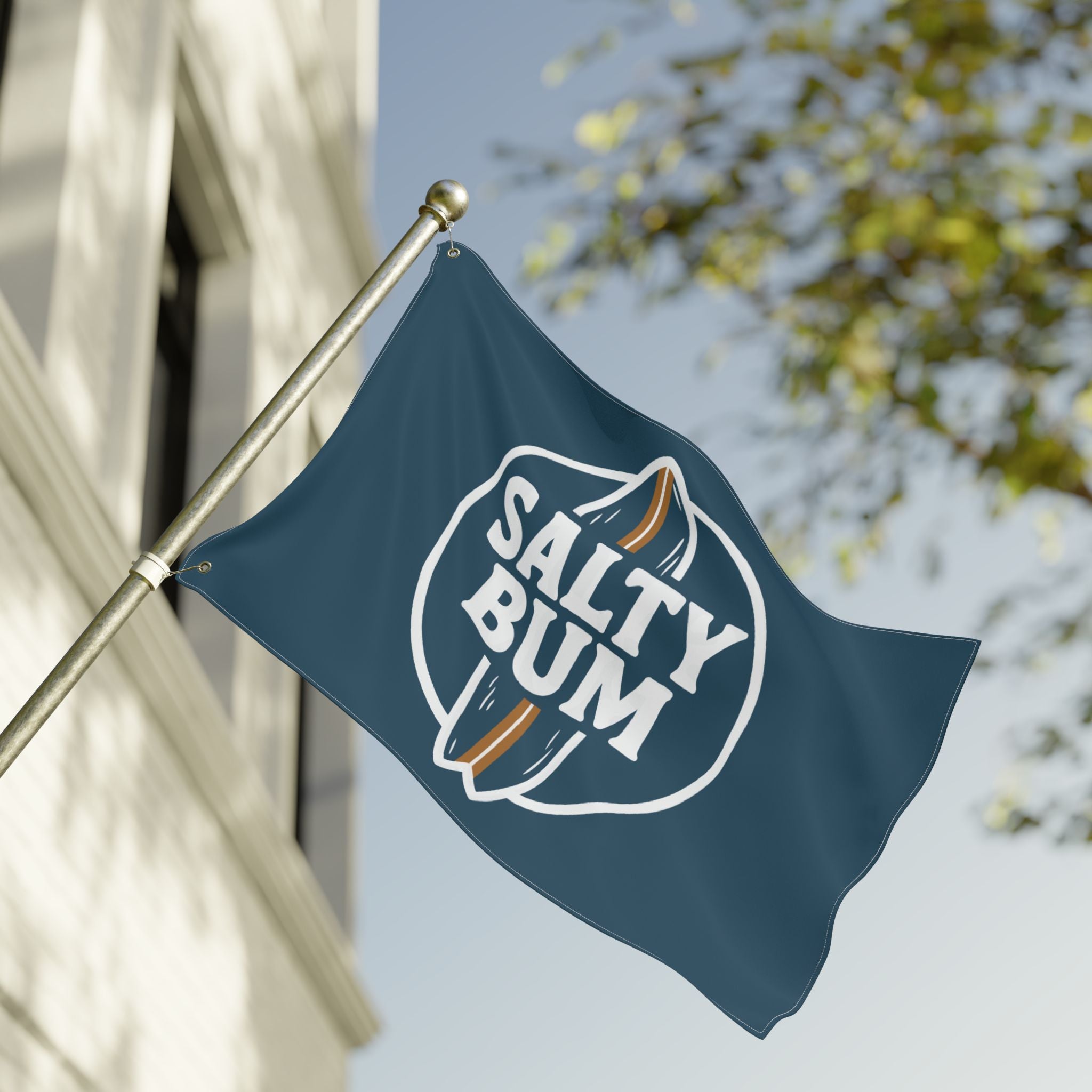 Flag with 'Salty Bum' logo on a flagpole against a clear sky.