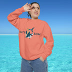 Person wearing an orange sweatshirt with a shark graphic and text, standing in front of a clear blue sky and ocean.