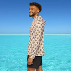 Man wearing a patterned shirt standing in front of clear blue water and sky
