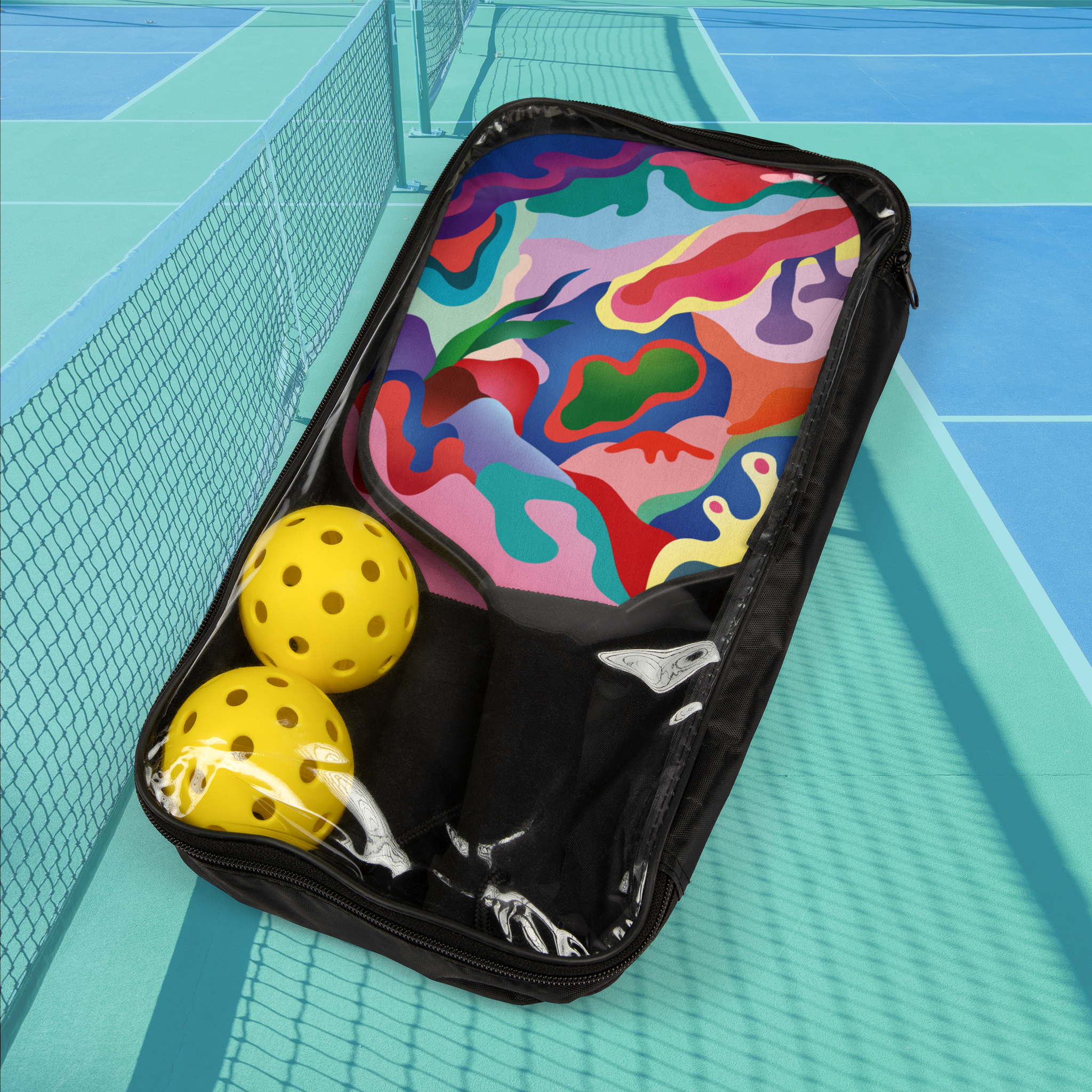 Colorful pickleball paddle case with two yellow pickleballs on a pickleball court.
