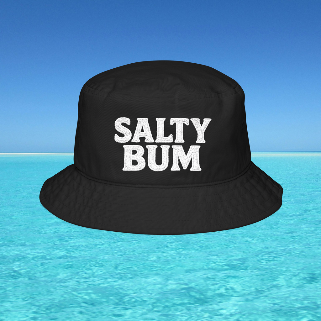 Black bucket hat with 'Salty Bum' text floating on water with a blue sky background