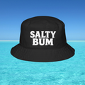 Black bucket hat with 'Salty Bum' text floating on water with a blue sky background