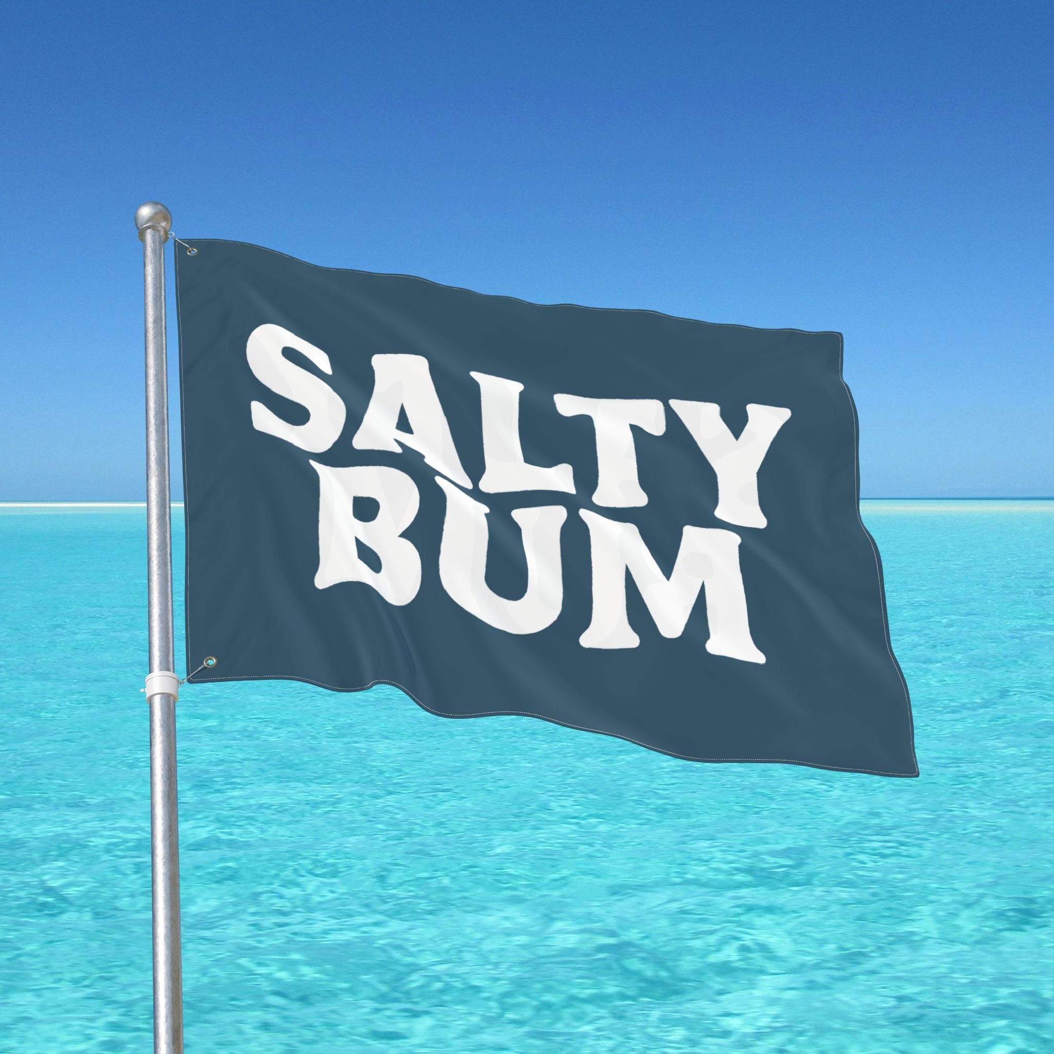 Flag with 'Salty Bum' text waving in front of a clear blue sky and ocean.