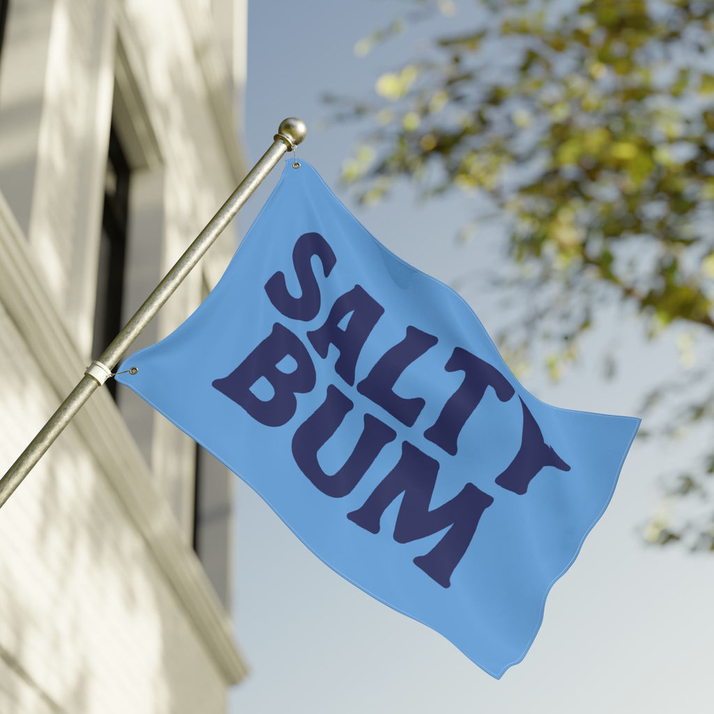 Blue flag with 'Salty Bum' text on a building facade