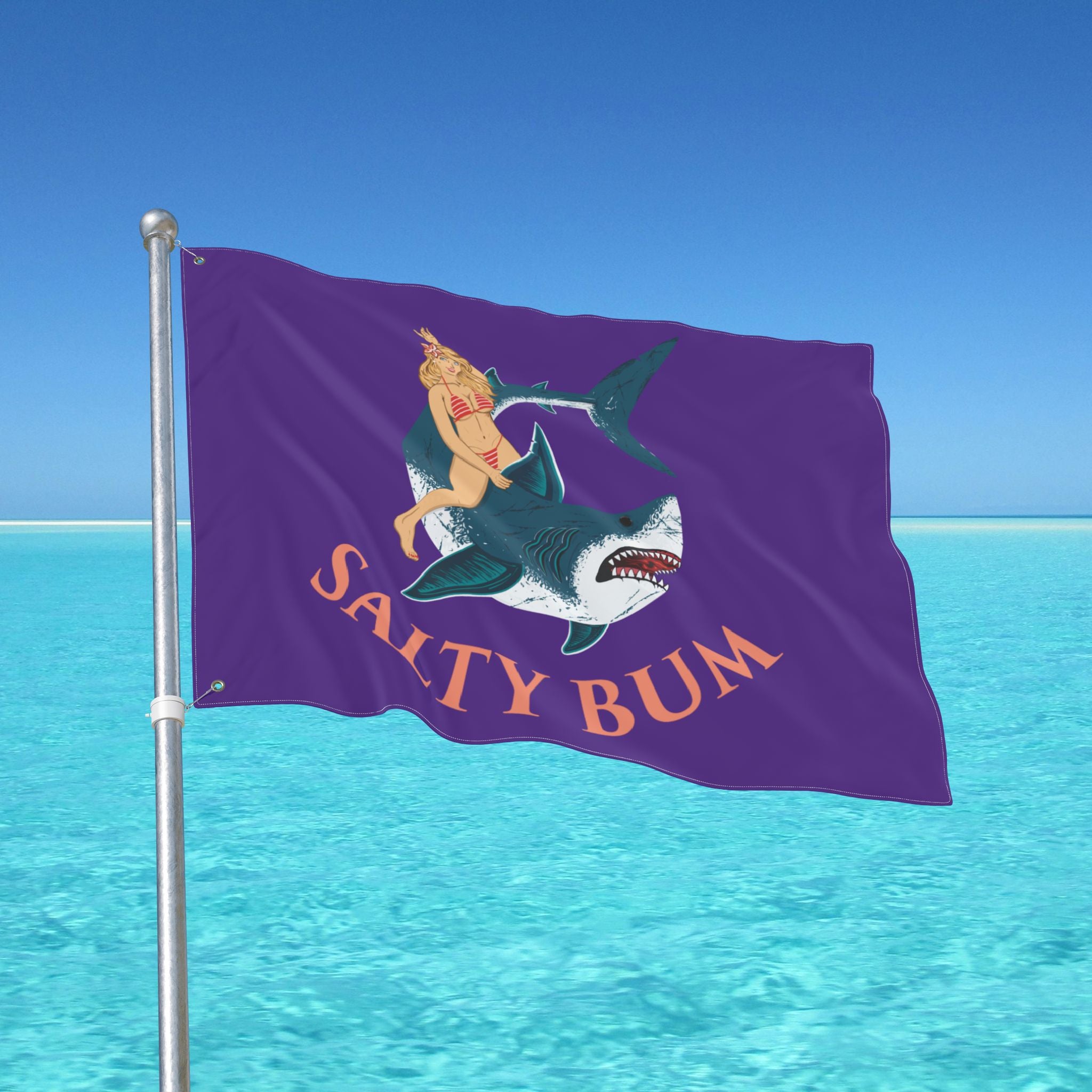 Flag with a shark and bikini-clad figure design against a blue ocean and sky background