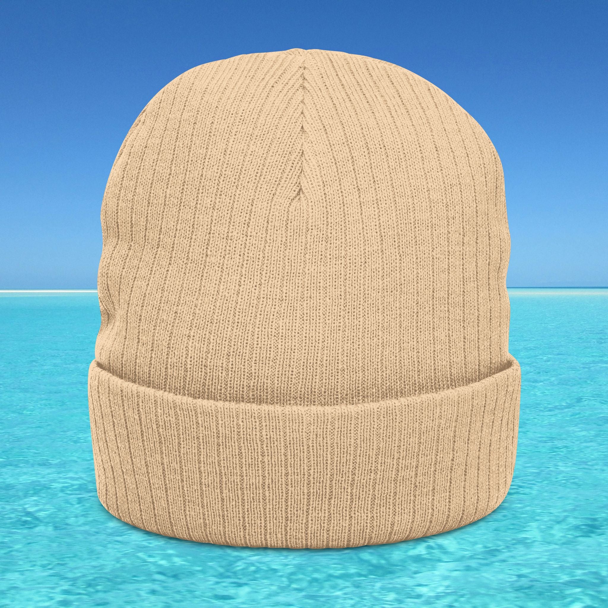 Beige knit beanie on a blue water and sky background