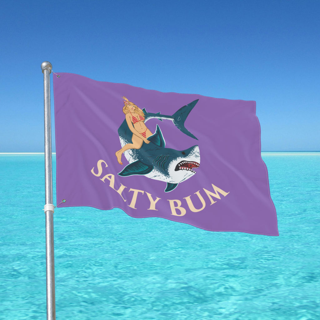Flag with a shark and bikini-clad figure design against a blue ocean background