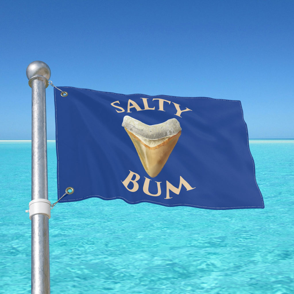 Flag with 'Salty Bum' text and a shark tooth graphic against a blue sky and ocean background.