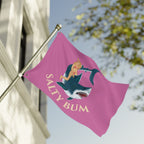 Pink flag with a graphic of a woman on a shark and 'Salty Bum' text, attached to a flagpole outdoors.